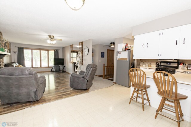 living room with sink, ceiling fan, and light wood-type flooring