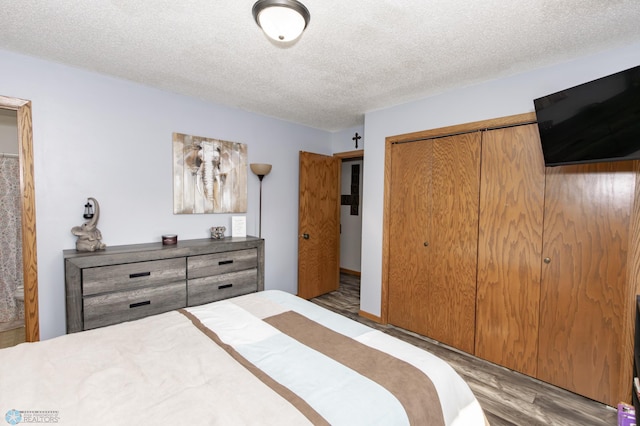 bedroom featuring light wood-type flooring, a closet, and a textured ceiling