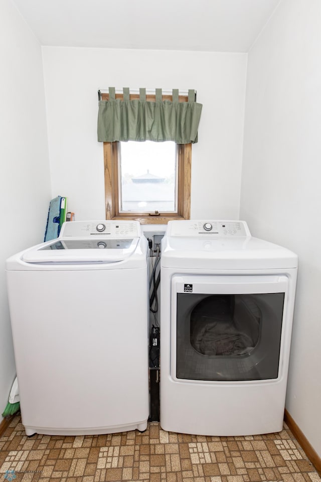 clothes washing area featuring light tile patterned flooring and washing machine and dryer