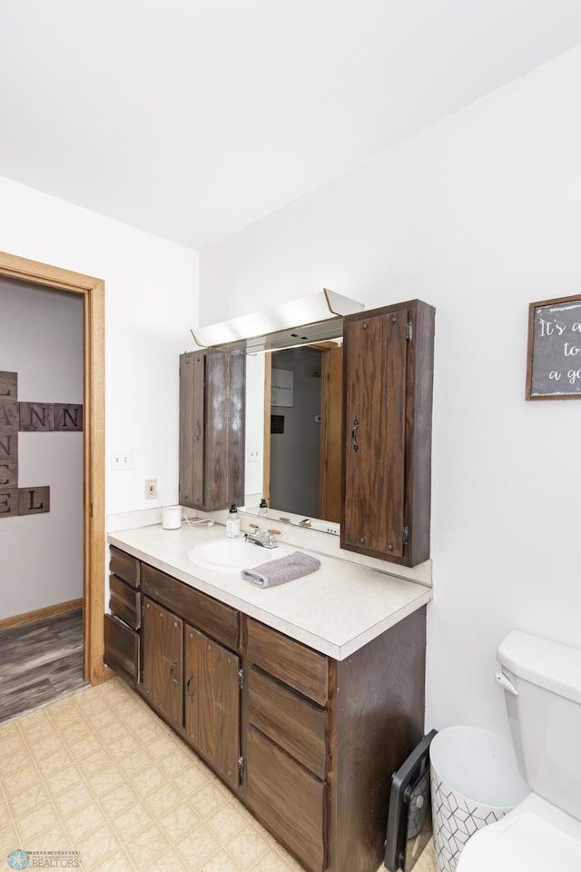 bathroom featuring vanity, hardwood / wood-style floors, and toilet