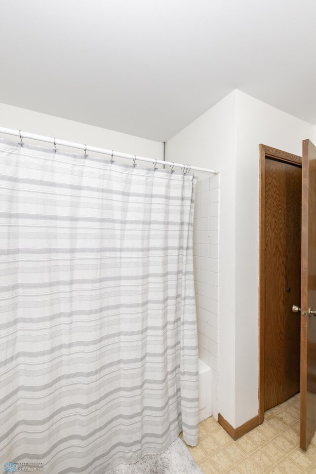 bathroom featuring tile patterned flooring and shower / tub combo with curtain