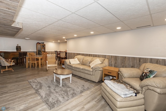 living room featuring a drop ceiling and hardwood / wood-style floors