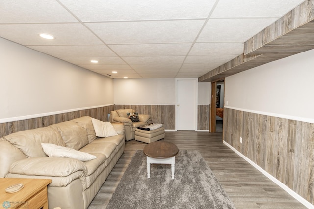 living room with a paneled ceiling and wood-type flooring