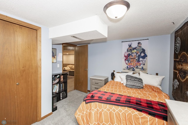 bedroom with a closet, light colored carpet, and a textured ceiling