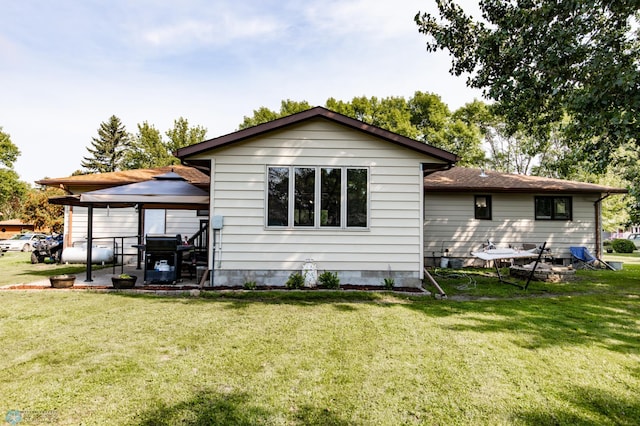 back of house featuring a yard and a gazebo