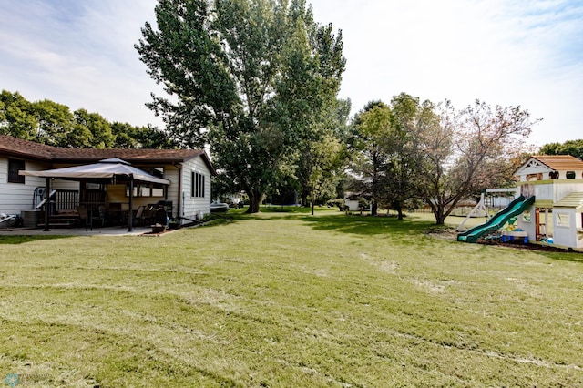 view of yard featuring a playground and a patio