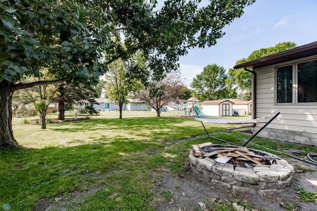 view of yard with a storage shed and an outdoor fire pit