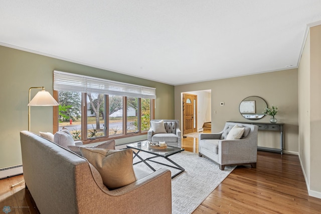 living room with ornamental molding, wood-type flooring, and a baseboard radiator