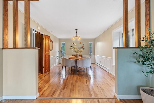 dining room featuring an inviting chandelier, baseboard heating, and hardwood / wood-style floors