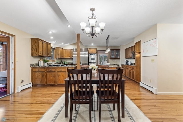 dining area featuring light hardwood / wood-style flooring, a notable chandelier, and a baseboard radiator