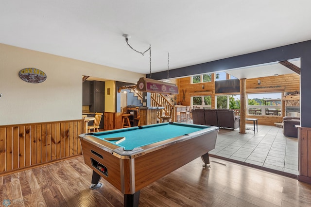 recreation room with light wood-type flooring, bar, wood walls, and billiards