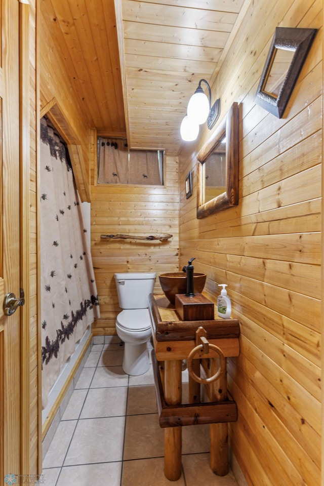 bathroom featuring tile patterned flooring, wooden walls, toilet, and wooden ceiling