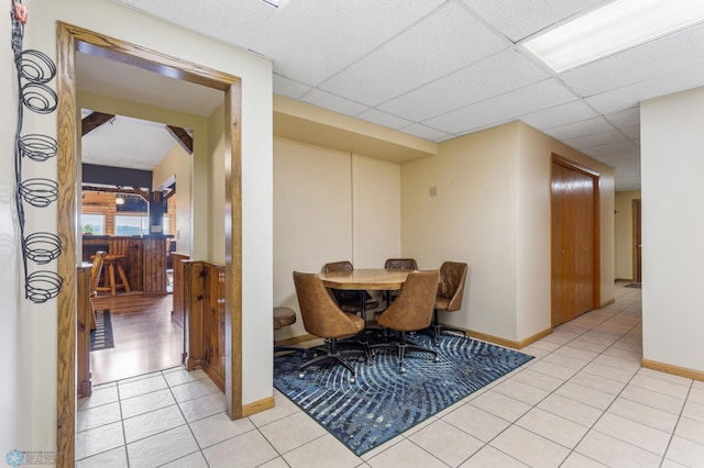 interior space with light tile patterned floors and a drop ceiling