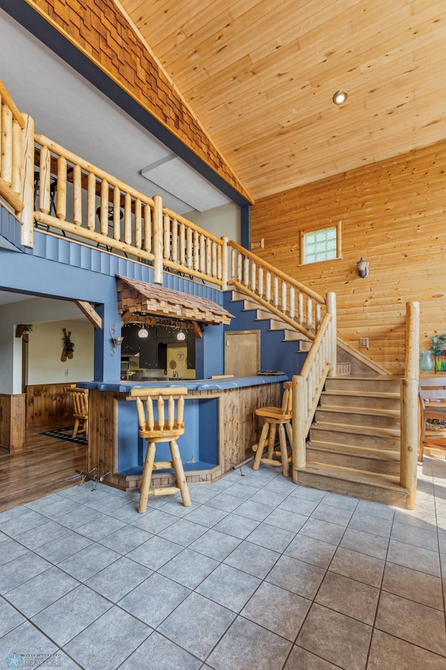 interior space with wood ceiling, high vaulted ceiling, and tile patterned floors