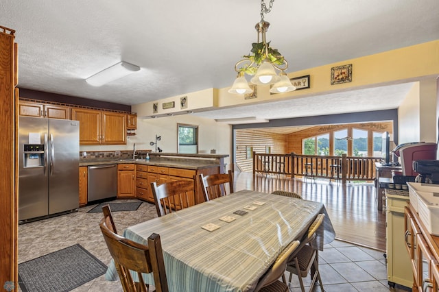 tiled dining space featuring sink and a textured ceiling