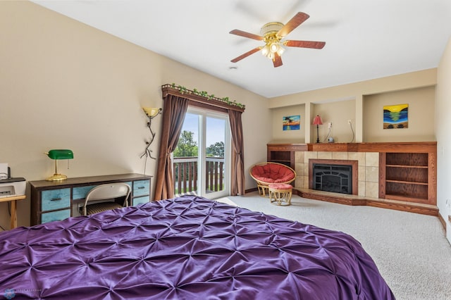 bedroom with carpet, access to outside, a tile fireplace, and ceiling fan