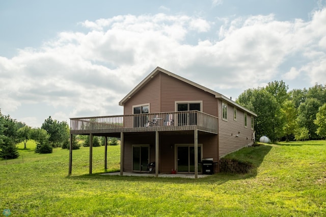 back of property featuring a deck and a lawn