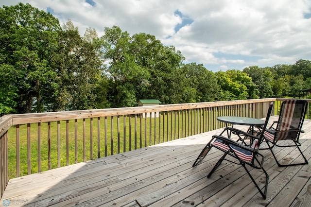 wooden terrace featuring a storage shed and a yard