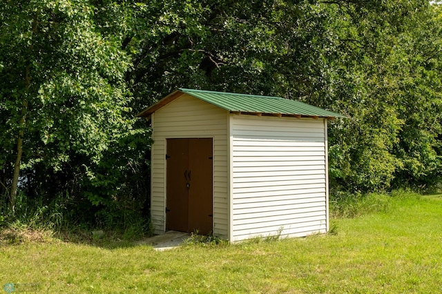 view of outbuilding featuring a yard