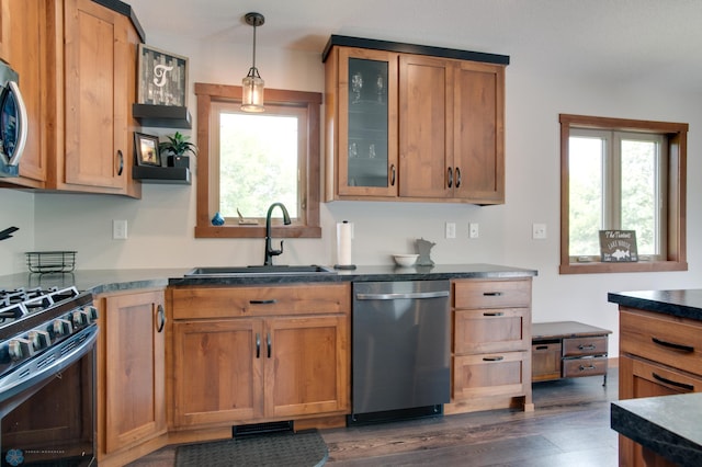 kitchen with sink, appliances with stainless steel finishes, dark hardwood / wood-style floors, and pendant lighting