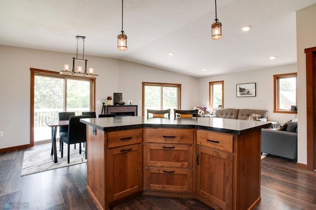 kitchen with dark hardwood / wood-style floors, a center island, decorative light fixtures, and lofted ceiling