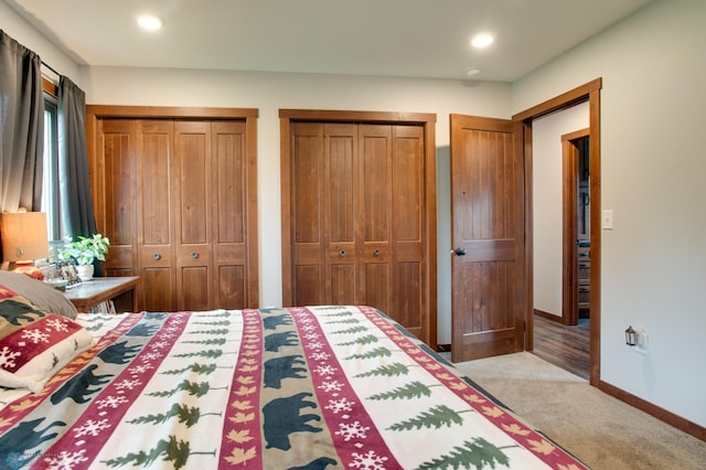 unfurnished bedroom featuring carpet and two closets