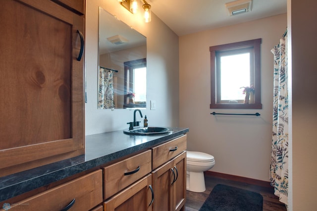 bathroom with wood-type flooring, vanity, and toilet