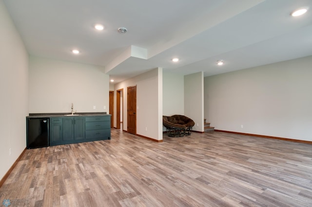 basement featuring light wood-type flooring and sink