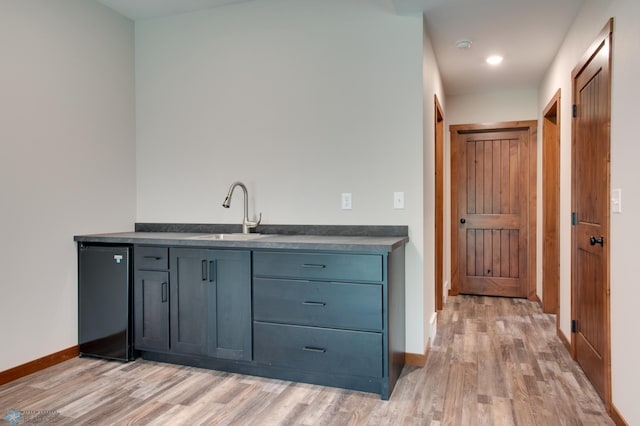 bar with sink and light hardwood / wood-style flooring