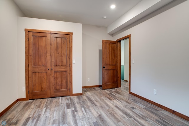 unfurnished bedroom featuring hardwood / wood-style flooring and a closet