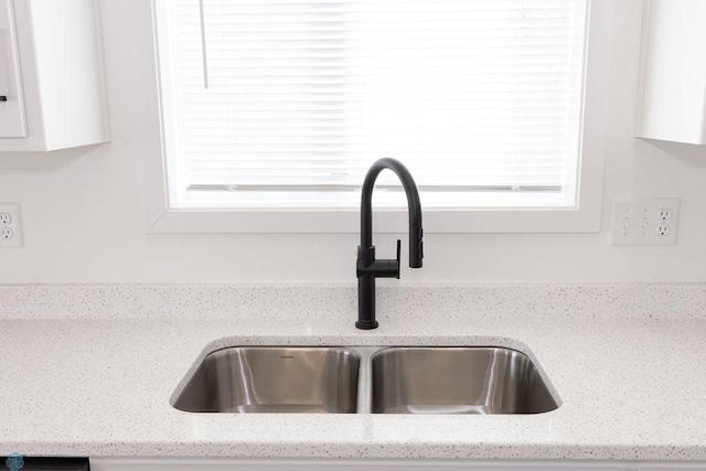 interior details with light stone countertops and sink