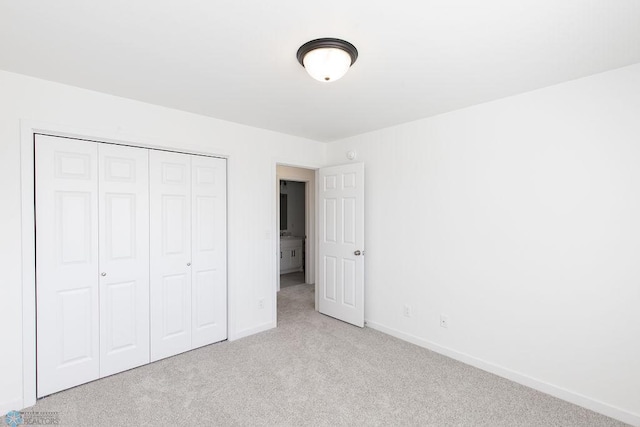 unfurnished bedroom with a closet and light colored carpet