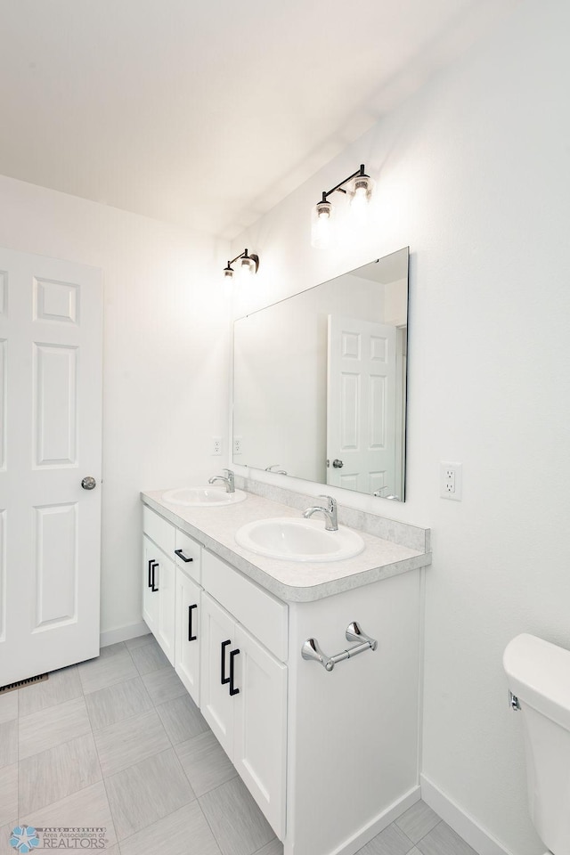 bathroom with tile patterned flooring, toilet, and vanity