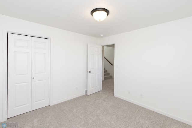 unfurnished bedroom featuring a closet and light carpet