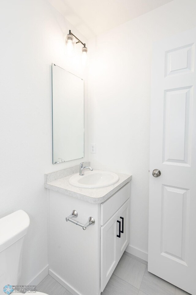 bathroom with tile patterned floors, toilet, and vanity