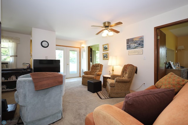 carpeted living room with ceiling fan and french doors