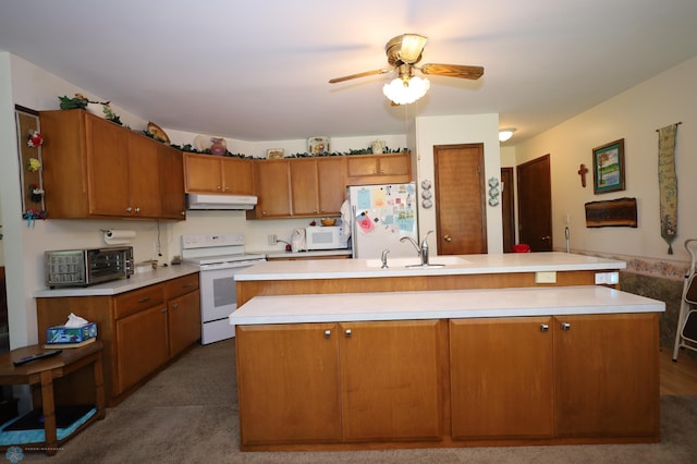 kitchen with sink, dark carpet, an island with sink, and white appliances