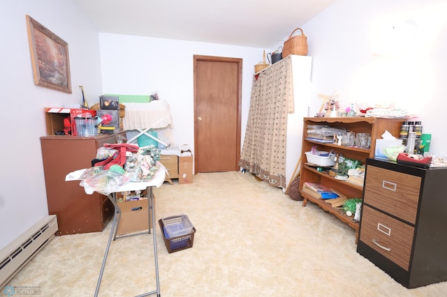 recreation room featuring a baseboard heating unit and light carpet