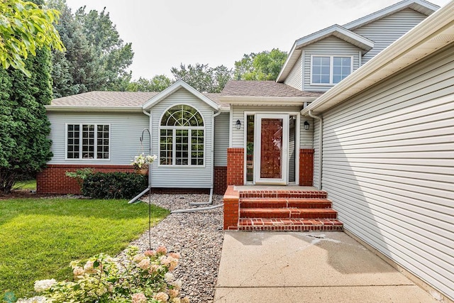 view of exterior entry with a yard