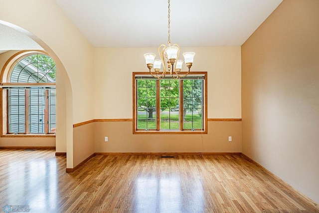 unfurnished room featuring light wood-type flooring and a chandelier