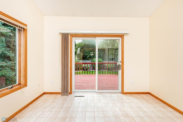 empty room with a wealth of natural light and light tile patterned floors