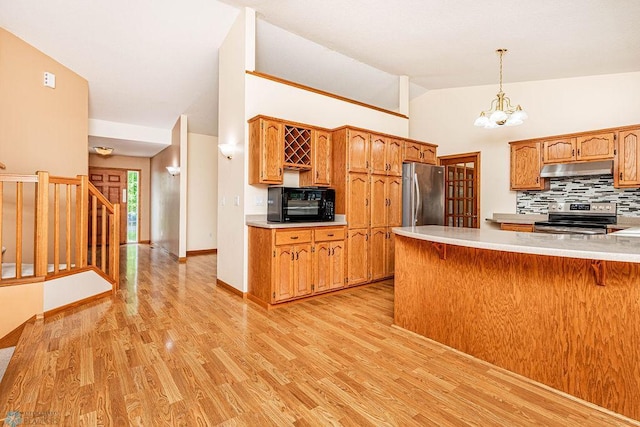 kitchen with vaulted ceiling, an inviting chandelier, decorative light fixtures, stainless steel appliances, and light wood-type flooring