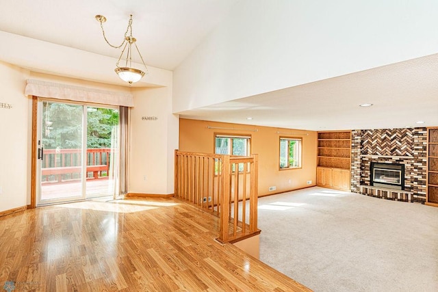 unfurnished living room with a fireplace, built in features, high vaulted ceiling, and hardwood / wood-style floors