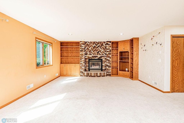 unfurnished living room with a brick fireplace, built in shelves, and carpet flooring