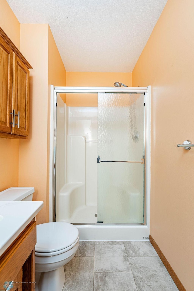 bathroom with tile patterned flooring, toilet, a shower with door, and vanity