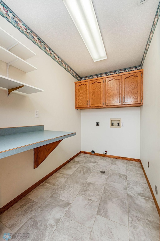 laundry area featuring a textured ceiling, cabinets, electric dryer hookup, and washer hookup