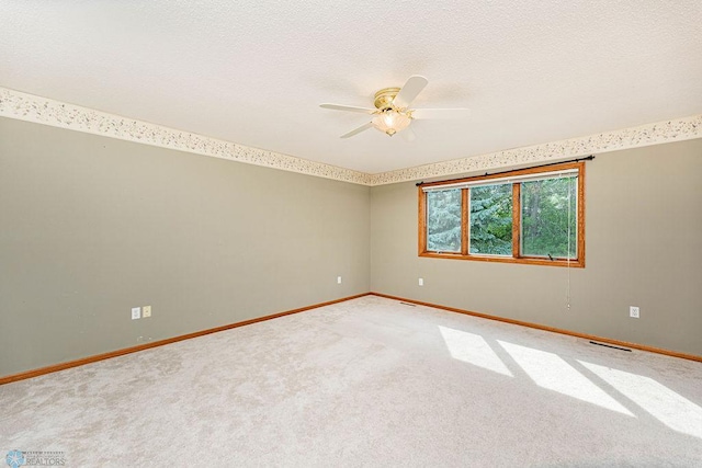 carpeted spare room with a textured ceiling and ceiling fan