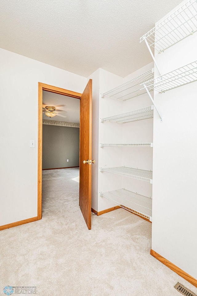 walk in closet featuring ceiling fan and carpet floors