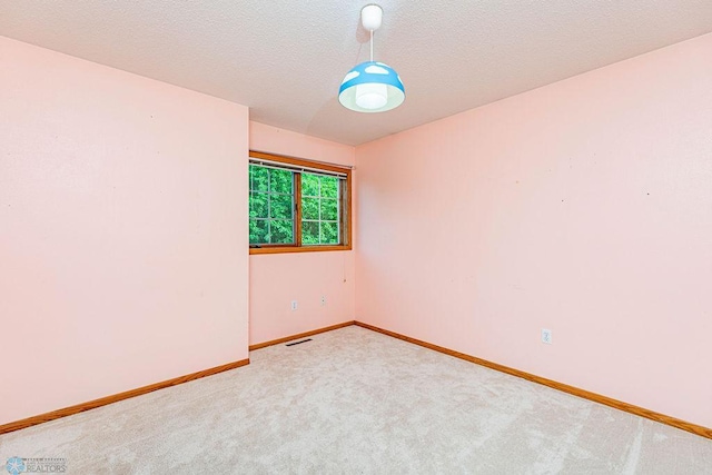 carpeted spare room with a textured ceiling