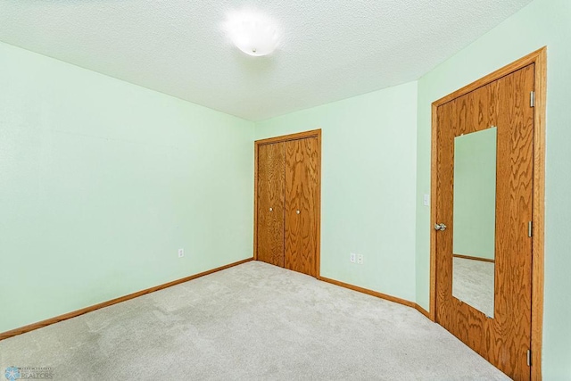 unfurnished bedroom featuring a textured ceiling and carpet